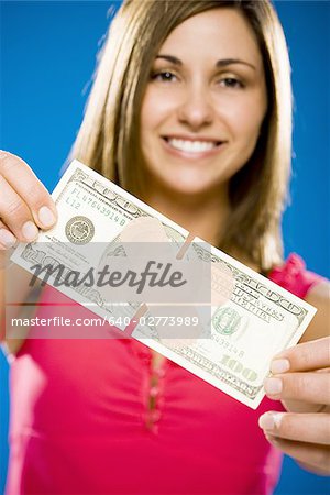 Woman with torn one hundred dollar American banknote with plastic strip