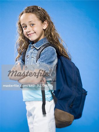 Smiling girl with arms crossed and backpack