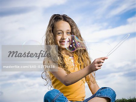 Girl outdoors with bubbles smiling