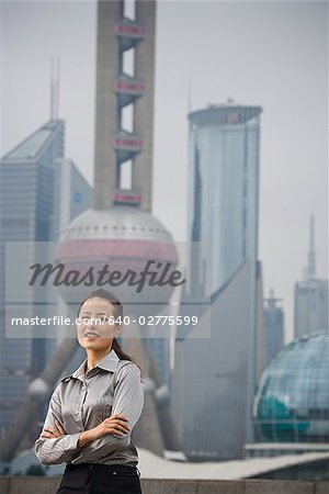 Businesswoman smiling outdoors with arms crossed