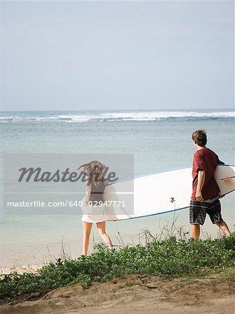 couple going to the beach to surf