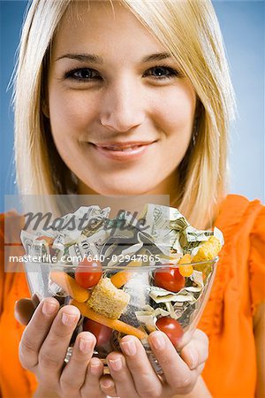 woman eating a salad made of money