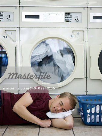 man sleeping at a laundromat