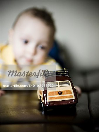 baby boy playing with a toy car