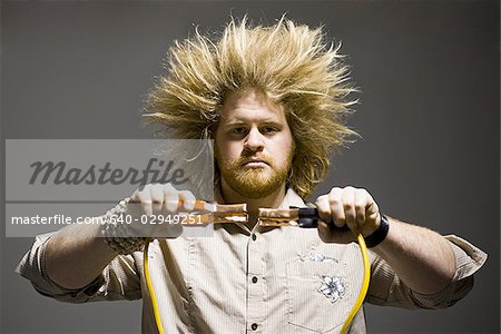 man with crazy hair holding jumper cables