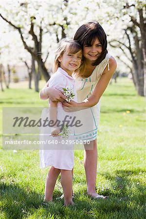 two girls in a blossoming orchard