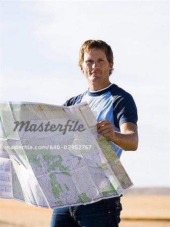 man looking at a map on the side of the road