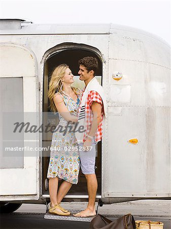 couple in front of their airstream classic trailer