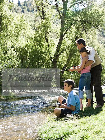 dad teaching his children to fish