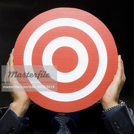 man holding a red target in front of his face