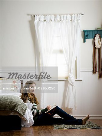 woman sitting on the floor of her bedroom writing in a journal