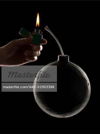 hand lighting the wick on a bomb