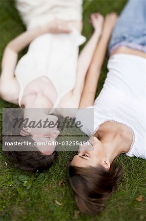 Two women laying in the grass