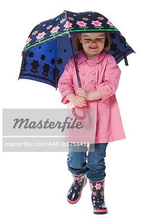 Studio portrait of girl (2-3 years) holding umbrella over head