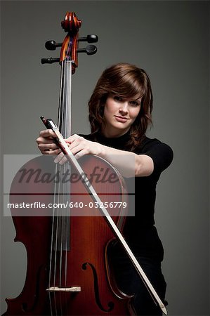 Studio portrait of young woman with cello