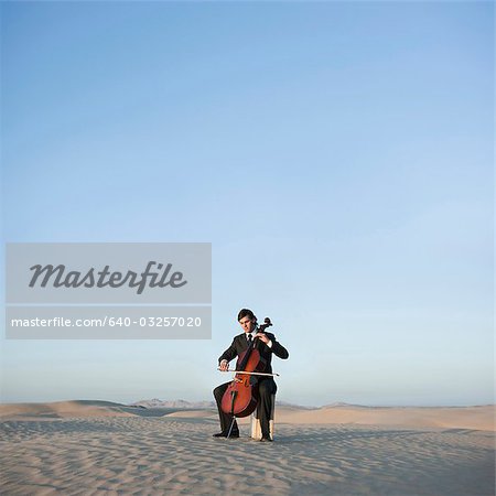 USA, Utah, Little Sahara, young man with cello in desert