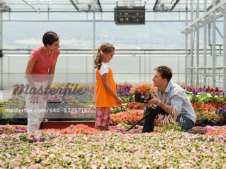 USA, Utah, Salem, girl (8-9) with parents choosing plants in greenhouse