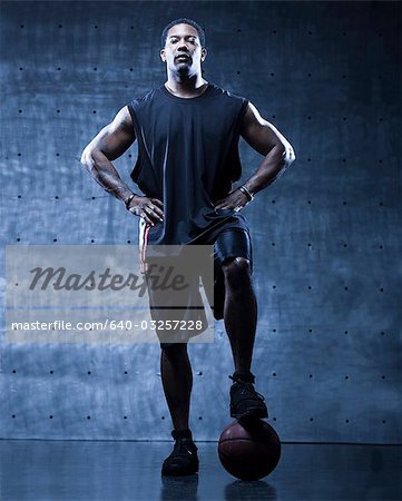 Mid adult man posing with basketball, portrait