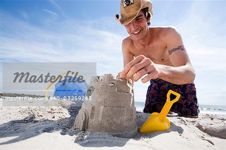 Man building a sand castle at the beach