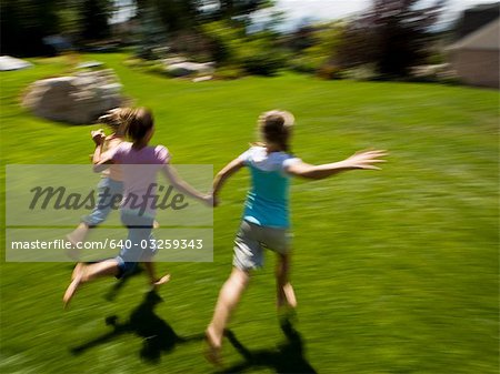 Three girl friends running outside
