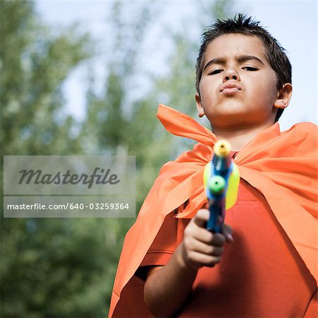 Boy in orange cape with water gun