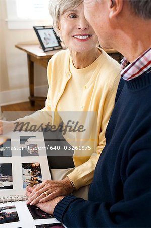 Rear view of mature couple with photo album