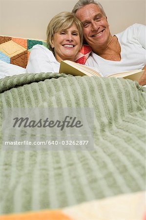 Mature couple in bed reading