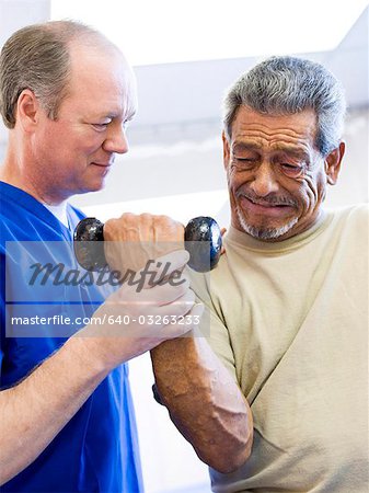 Physical Therapist assisting a man with weights