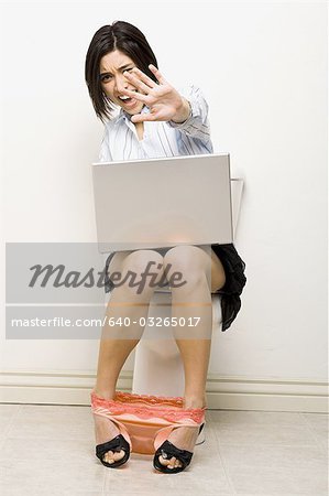 Woman on toilet with laptop
