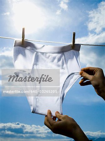 Portrait of a teenage girl drying a bikini bottom on a clothesline