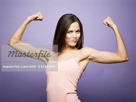 Woman flexing her biceps - Stock Photo - Masterfile - Premium