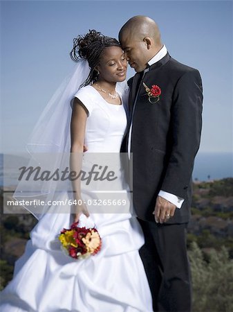 Newlywed couple standing together with their eyes closed