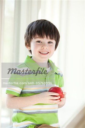 USA, Utah, Portrait of smiling boy (4-5) holding apple