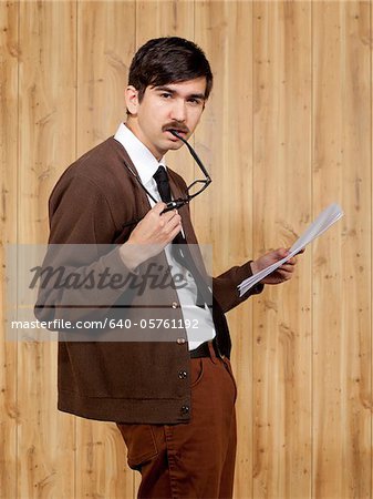 Portrait of businessman reading document in office