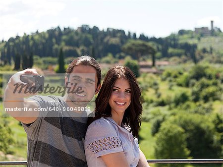 Italy, Florence, Young couple photographing themselves in rural area