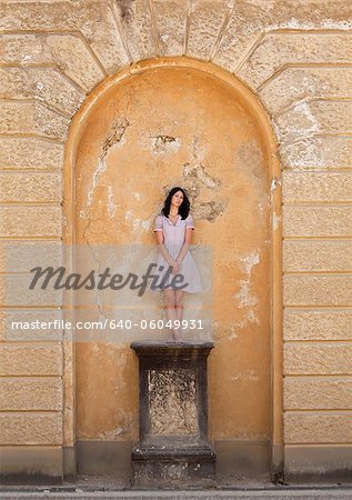 Italy, Florence, Portrait of young woman standing under arch