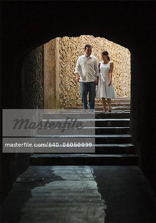 Italy, Ravello, Mature couple walking in dark archway