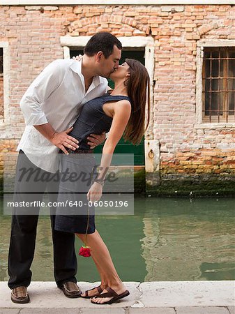 Italy, Venice, Mature couple kissing on bridge