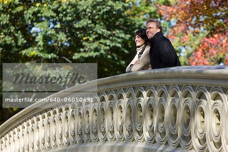 USA, New York City, Manhattan, Central Park, Mature couple standing on bridge in Central Park