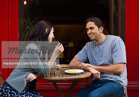 France, Paris, Young couple sitting in sidewalk cafe