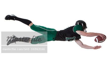 Male player of American football catching ball, studio shot