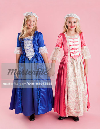 Portrait of two girls (10-11) in colonial princess dresses for Halloween