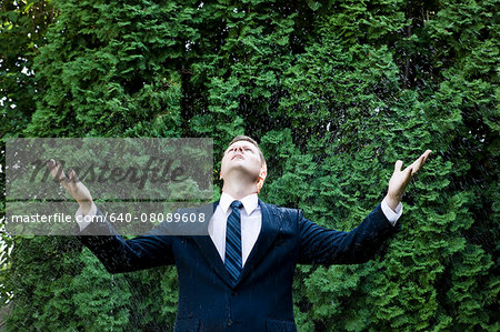man in a suit standing next to a sprinkler