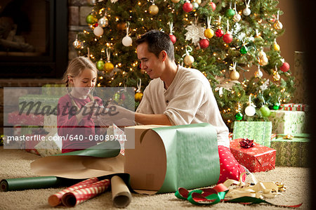 father and daughter wrapping a christmas gift together