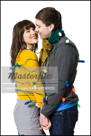 couple wrapped together with christmas lights