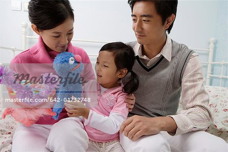 Family playing with puppet in the bedroom