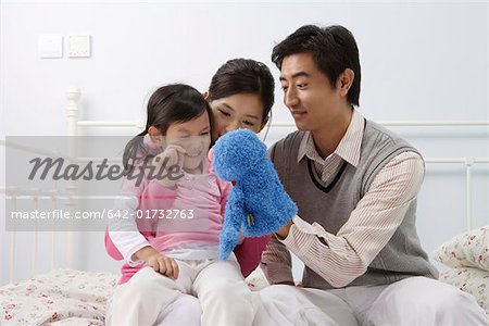 Family playing with a puppet in the bedroom