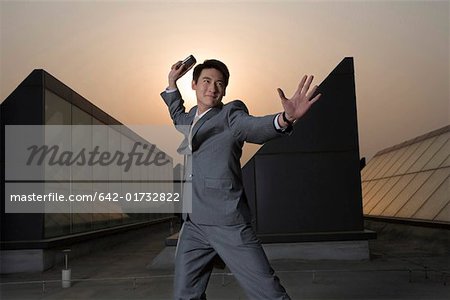 Businessman throwing mobile phone