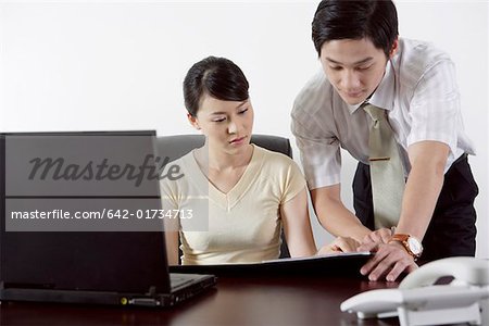 Businessman and a businesswoman looking at a file