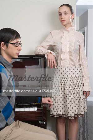 Young couple by grand piano, portrait